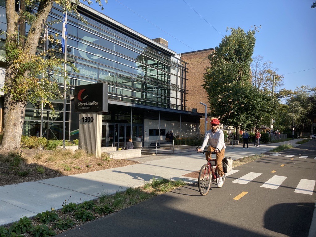 étudiant à vélo devant l'entrée du Cégep