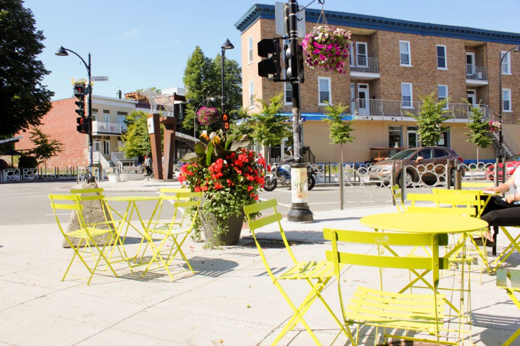 Des chaises et des tables sont disposés sur une terrasse extérieure ensoleillé.