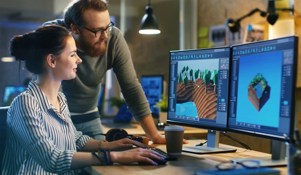 Un homme et une femme devant deux écrans d'ordinateur, regardant un montage 3D.