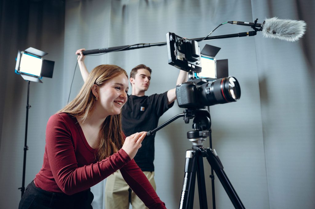 Deux étudiants en train de filmer et de capter le son lors d'un tournage.