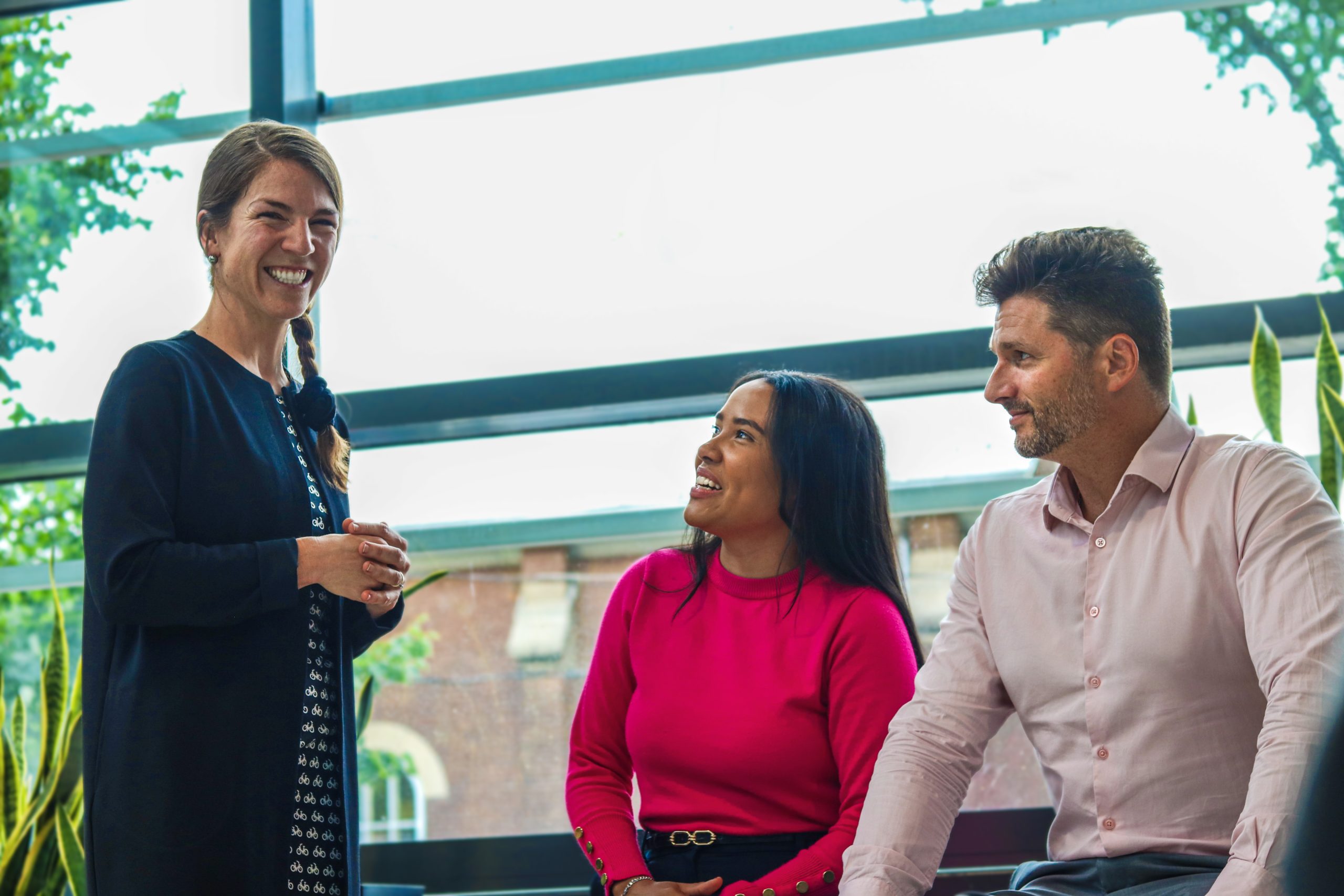 Des employés discutent dans la véranda ensoleillée.