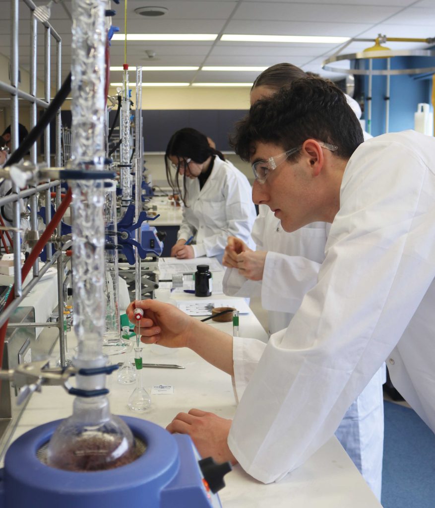 Étudiant en Sciences de la nature qui travaille dans un laboratoire, concentré sur sa tâche, avec une pipette à la main.