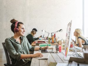 Une jeune femmes en agence travaille ses productions graphiqes