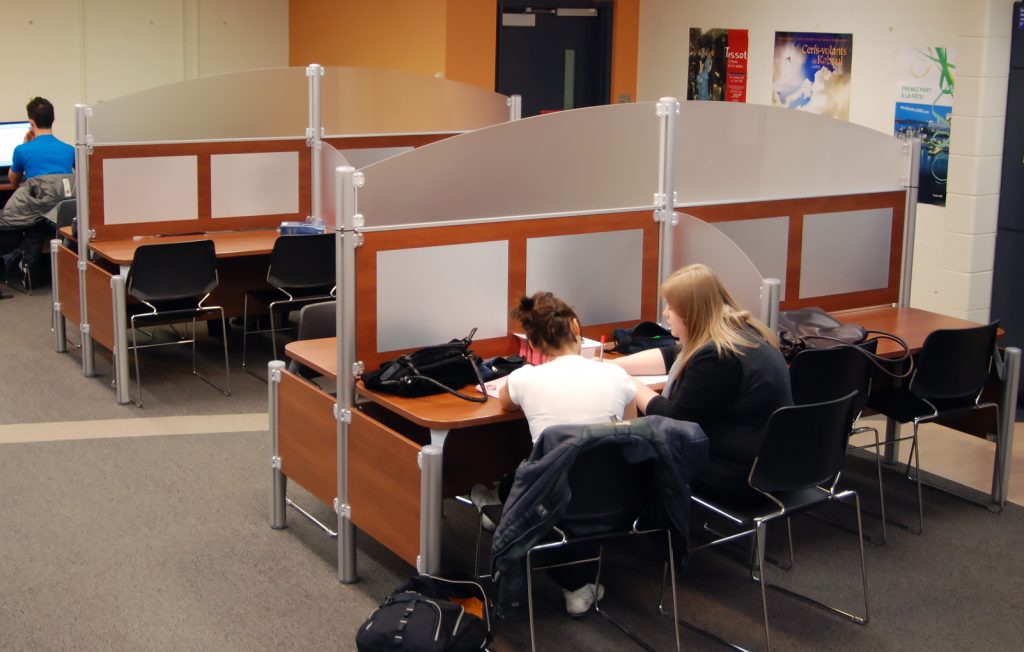 Deux étudiantes assises à un bureau à faire des travaux.