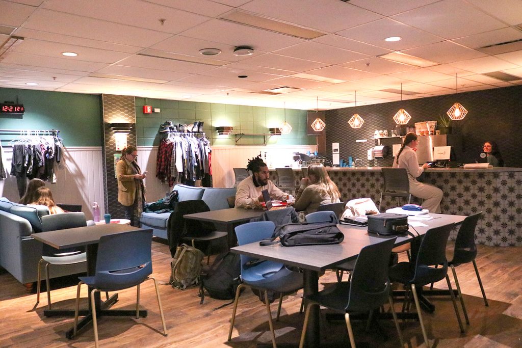 Café étudiant du campus de Charlesbourg, des étudiants y travaillant à des tableau ou mangeant un repas.