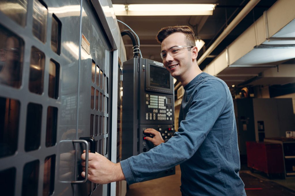 Étudiant devant une machine à commande numérique