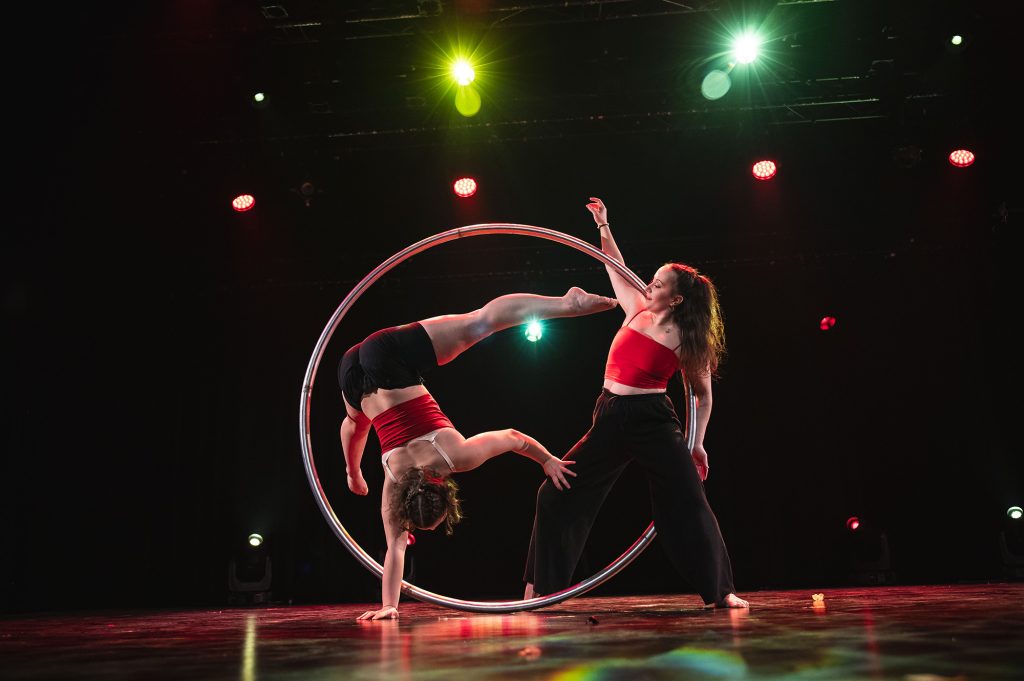 Deux étudiantes faisant des acrobaties de cirque avec un cerceau.