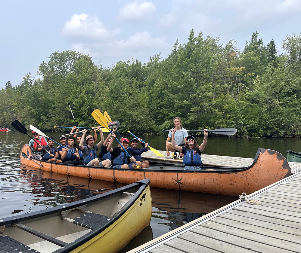 Étudiants internationaux en canot, tenant leur rame.