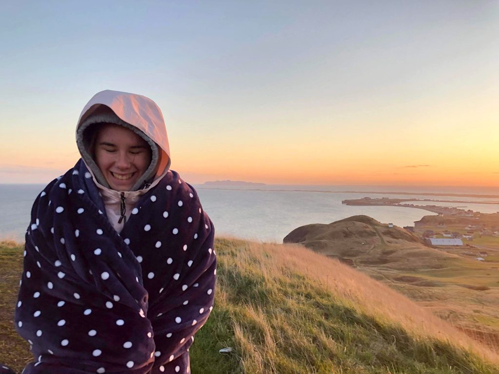 Étudiante devant un paysage des Îles-de-la-Madeleine