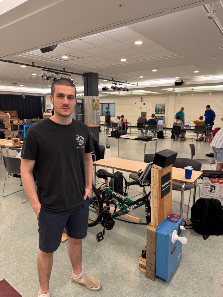 Théo Turgeon, finissant en Automatisation et contrôle. Il présente son vélo permettant de recharger un cellulaire et une ampoule, réalisé avec Marc-Antoine Paquette.