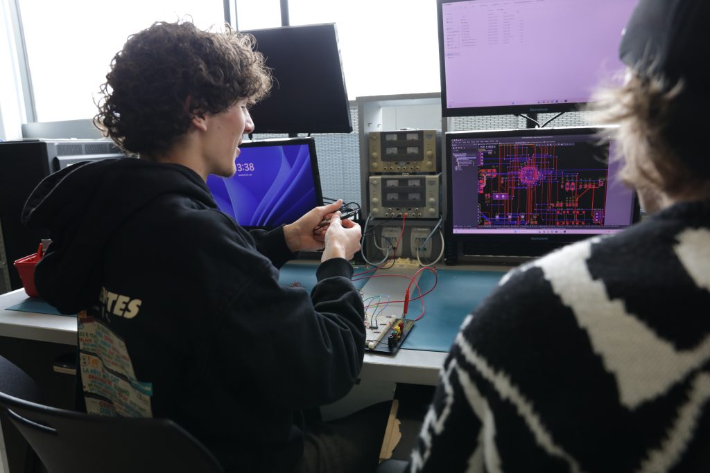 Deux étudiants dans un laboratoire de génie électrique travaillent un projet.