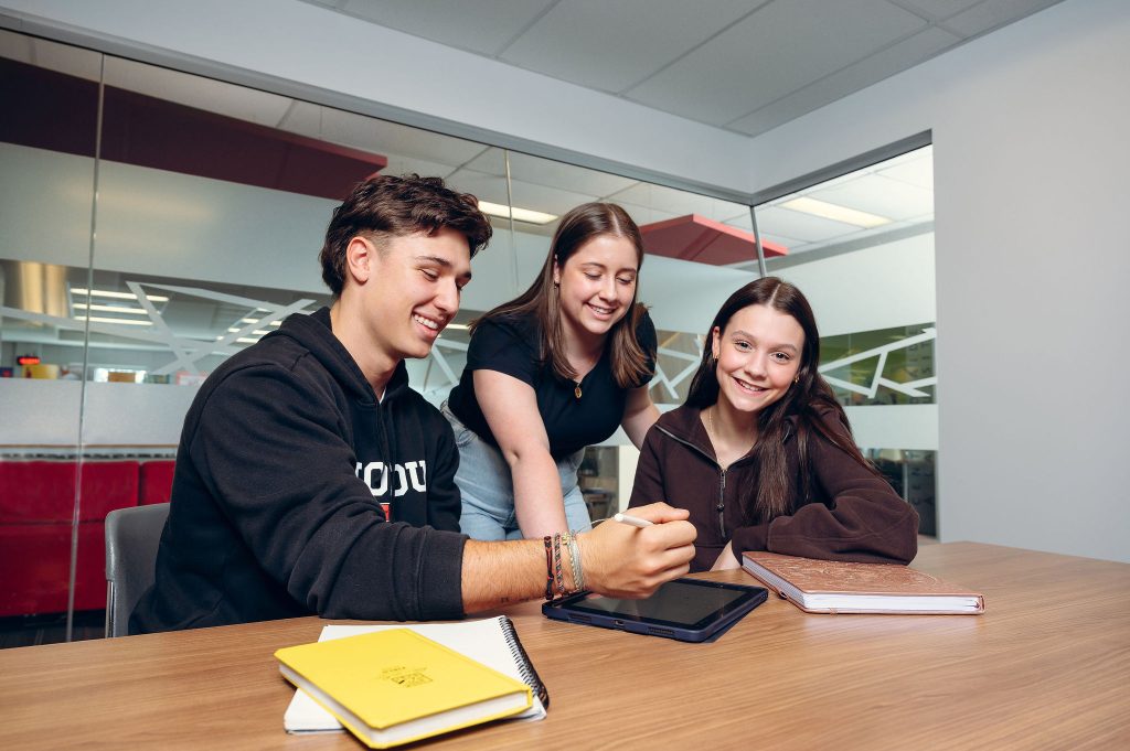 Trois étudiants travaillent à la bibliothèque