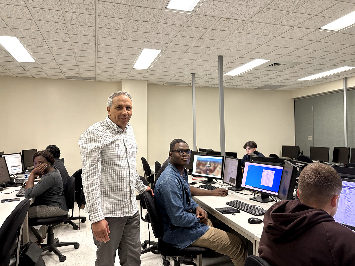 Une enseignant debout près de ses étudiants.